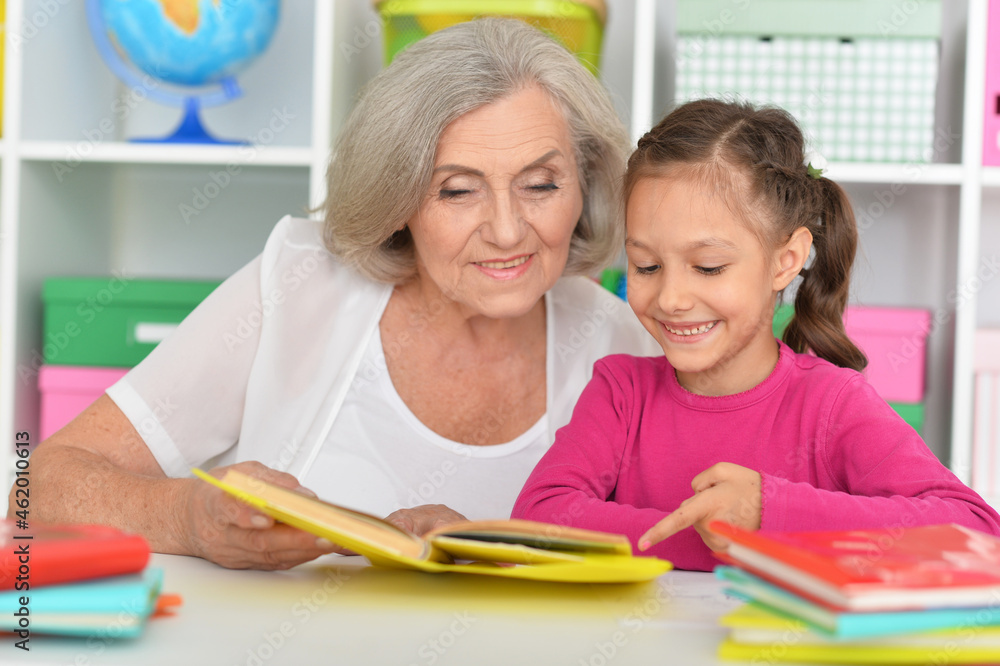 Little girl doing homework with her grandmother at home Little girl doing homework with her grandmother at home