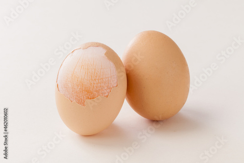 peeled egg shell expose the egg membrane on white background.