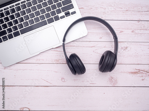 Top view of a laptop, headphones on a wooden table with copy space for text. Technology and relaxation concept