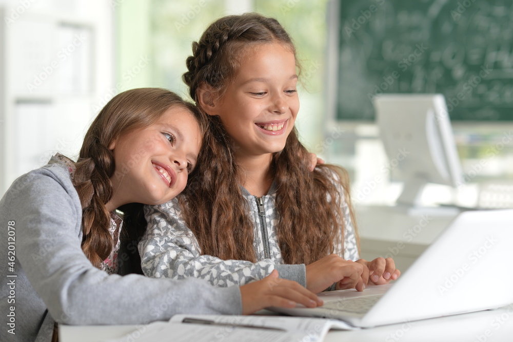 Beautiful girls studying at the desk with laptop in class room Beautiful girls studying at the desk with laptop in class room