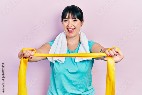 Young hispanic woman wearing sportswear and arm band smiling and laughing hard out loud because funny crazy joke.