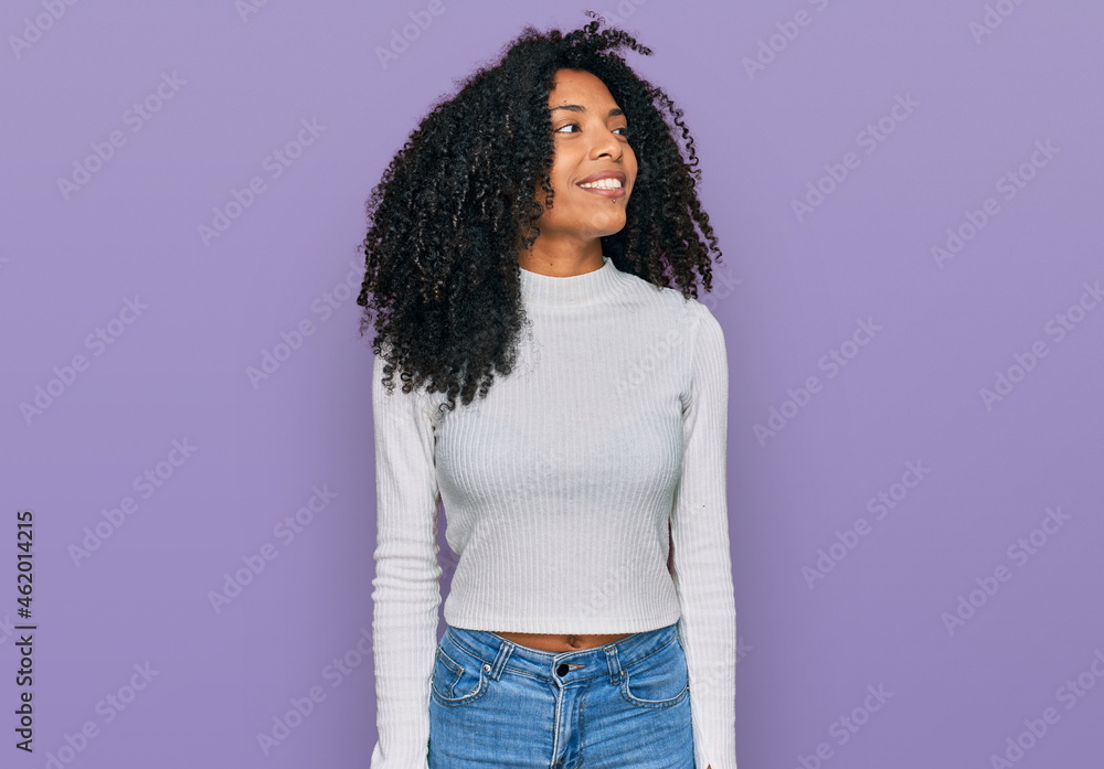 Young african american girl wearing casual clothes looking away to side with smile on face, natural expression. laughing confident. Young african american girl wearing casual clothes looking away to side with smile on face, natural expression. laughing confident.