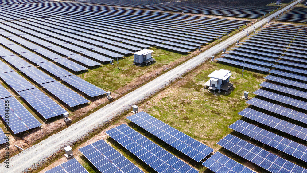 Naklejka premium Aerial view of a large scale solar panel farm. It harvesting sun's power to create a flow of electricity. Reduce Reuse and Restore concept