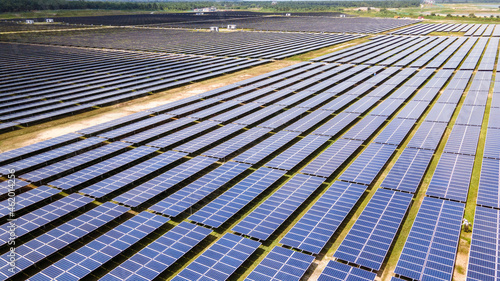 Aerial view of a large scale solar panel farm. It harvesting sun's power to create a flow of electricity. Reduce Reuse and Restore concept