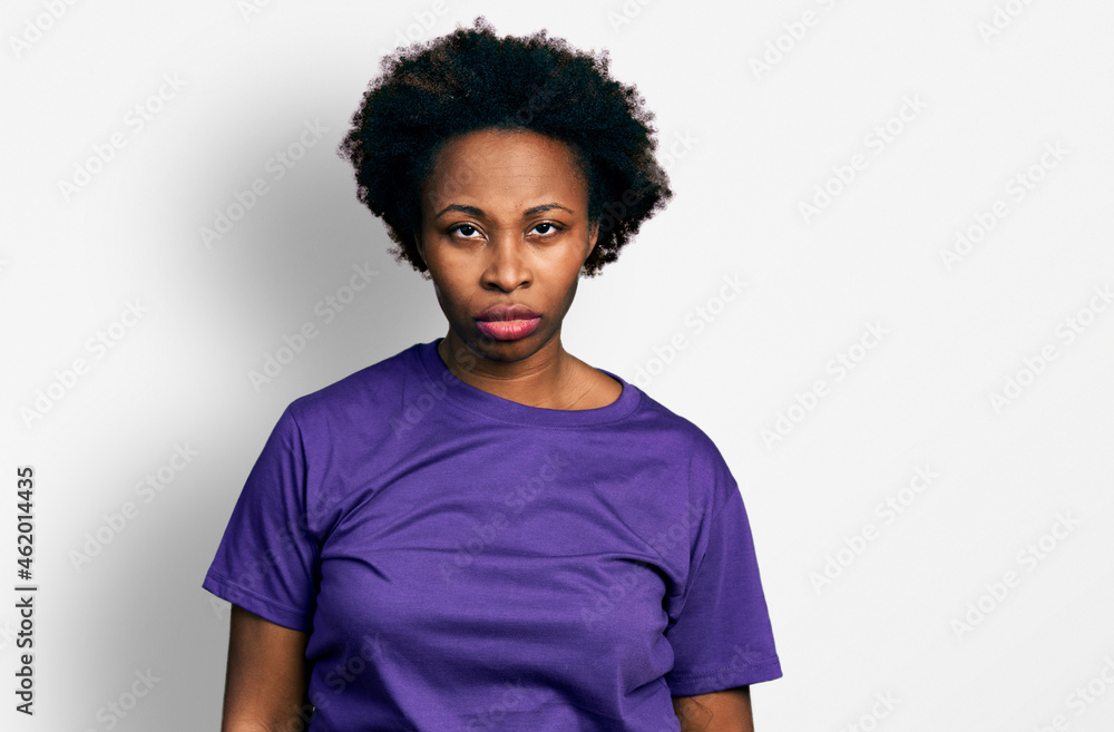 African american woman with afro hair wearing casual purple t shirt skeptic and nervous, frowning upset because of problem. negative person. African american woman with afro hair wearing casual purple t shirt skeptic and nervous, frowning upset because of problem. negative person.