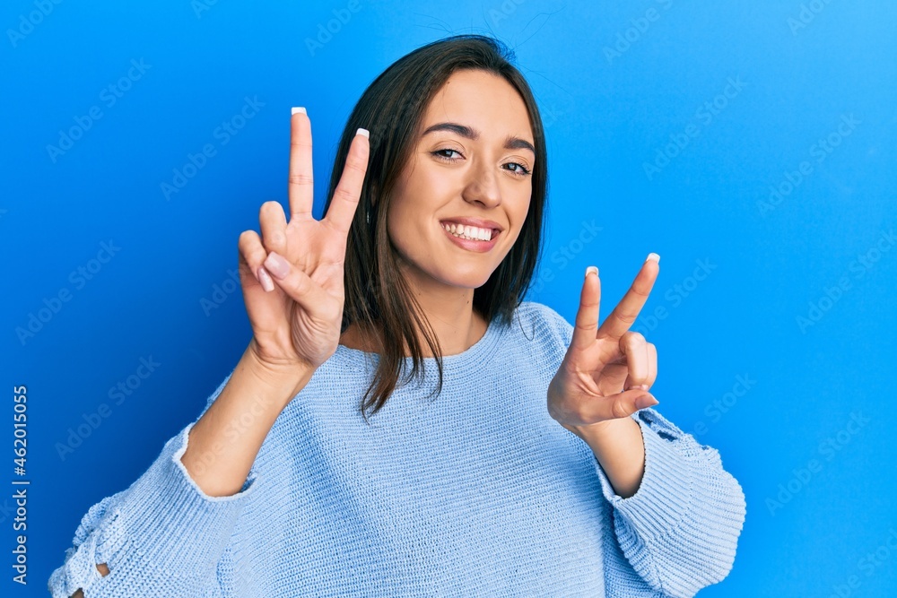 Young hispanic girl wearing casual clothes smiling looking to the camera showing fingers doing victory sign. number two. Young hispanic girl wearing casual clothes smiling looking to the camera showing fingers doing victory sign. number two.