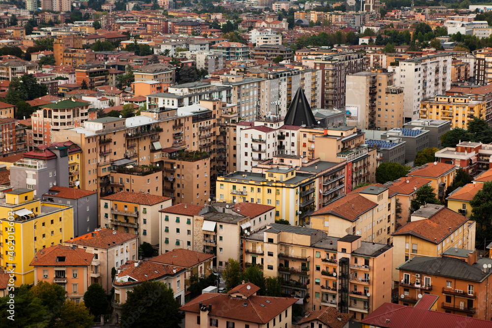 Aerial view of the modern centre of Brescia (Lombardy, Italy) with tiled red roofs, chimneys, cathedral's domes and tall white brick old towers. Traditional Italian buildings  architecture in Europe