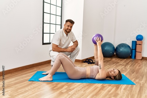 Physioterapist man giving rehab treatment to woman at the clinic.