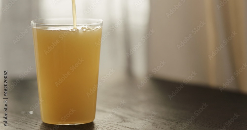pour orange juice in sparkling water in tumbler glass on black wood table with copy space pour orange juice in sparkling water in tumbler glass on black wood table with copy space