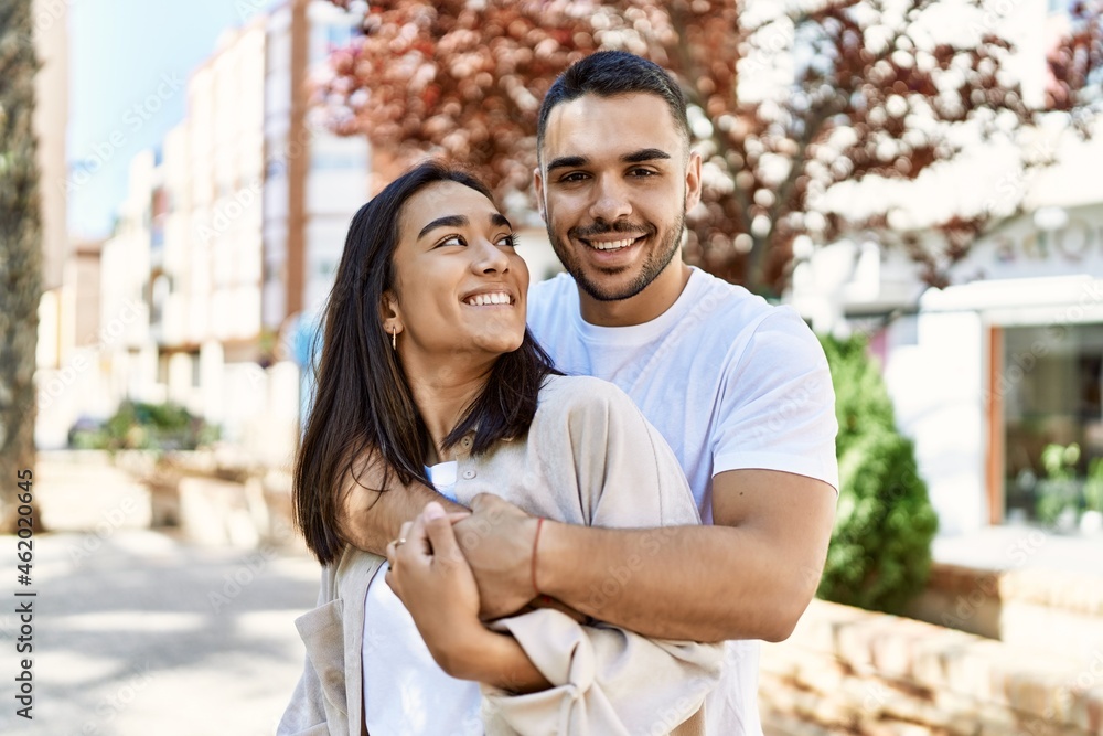 Young latin couple smiling happy and hugging at the city. Young latin couple smiling happy and hugging at the city.