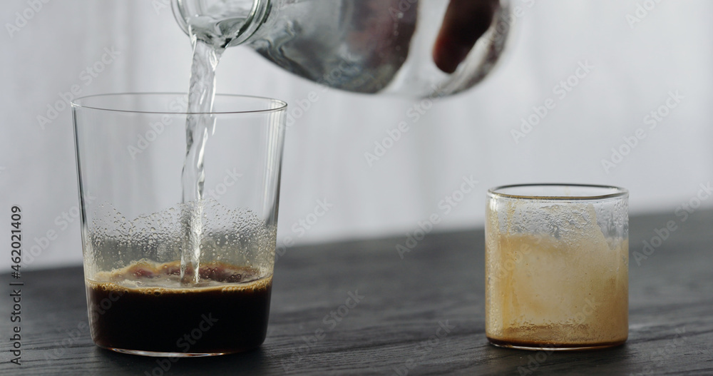 making espresso tonic pour tonic in espresso on black wood table making espresso tonic pour tonic in espresso on black wood table