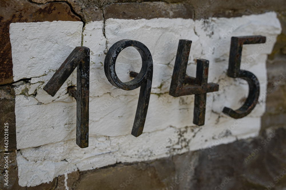1945, Gußeiserne Zahlen vor weißem Hintergrund einer Bruchsteinwand 1945, Gußeiserne Zahlen vor weißem Hintergrund einer Bruchsteinwand