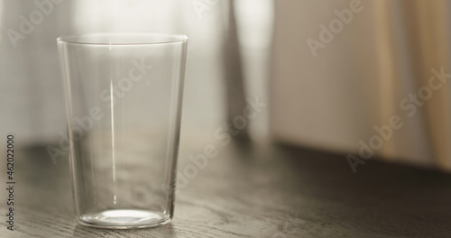 empty tumbler glass on black oak table