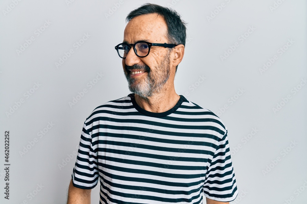 Middle age hispanic man wearing casual clothes and glasses looking to side, relax profile pose with natural face and confident smile. Middle age hispanic man wearing casual clothes and glasses looking to side, relax profile pose with natural face and confident smile.