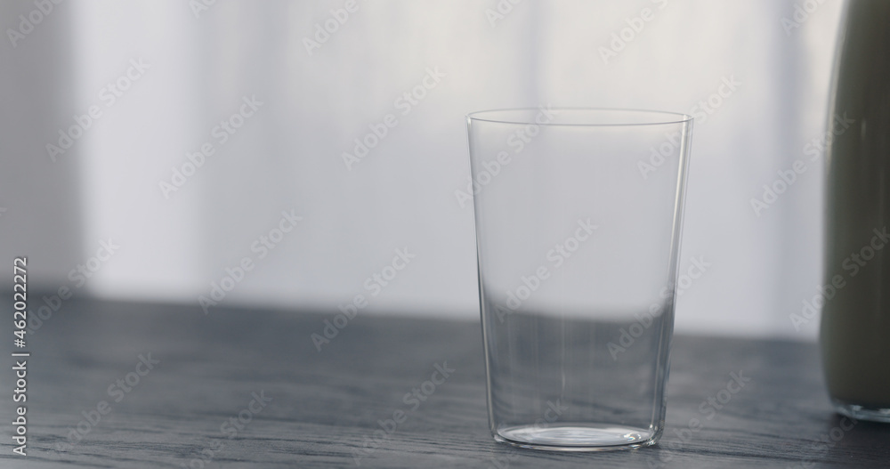 empty tumbler glass on black oak table empty tumbler glass on black oak table