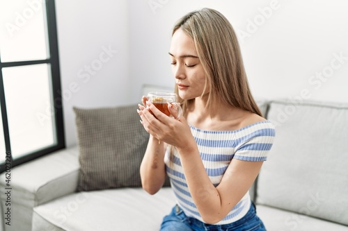 Young chinese woman smiling confident drinking tea at home