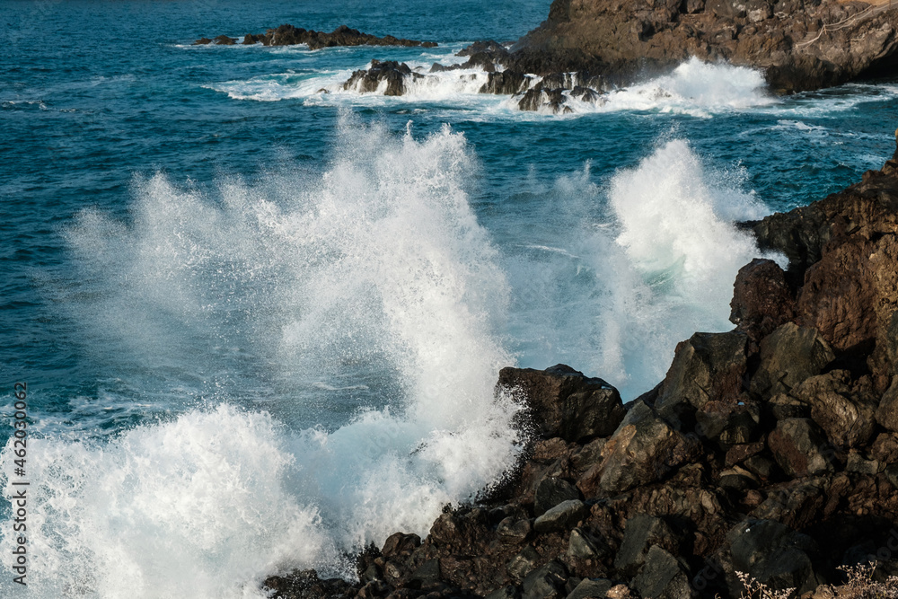 Waves crashing at rocks. Stormy weather at ocean coast .