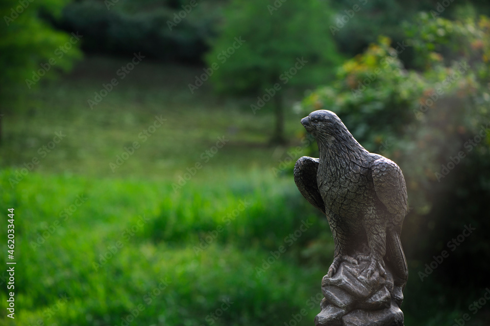 eagle sculpture in the park. plaster eagle, in the autumn city park. close-up, against a background of green grass, summer or autumn season eagle sculpture in the park. plaster eagle, in the autumn city park. close-up, against a background of green grass, summer or autumn season