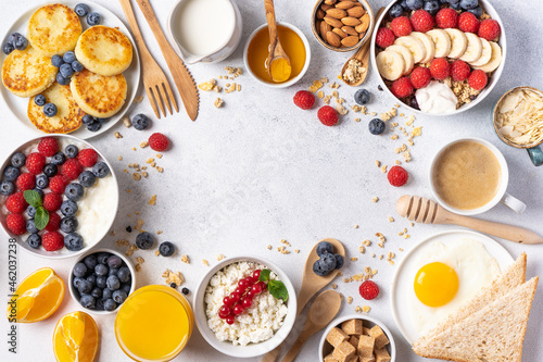 Frame of continental breakfast is captured from above, top view. Coffee, croissants, granola, Belgian waffles, honey, jam. Layout with free text space, copy space