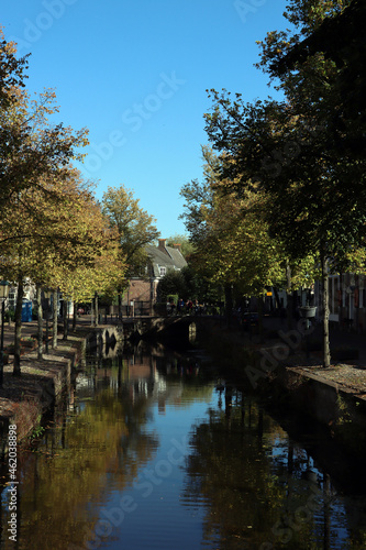 Fall season in a city. Autumn trees, buildings on canal, colorful water reflections. Autumn in the Netherlands. 