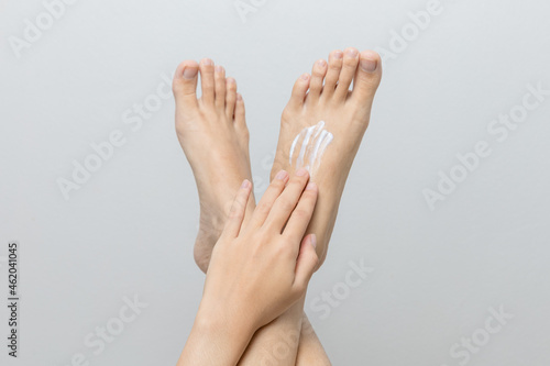 woman applying cream to her feet