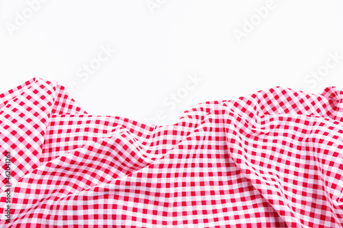 Checkers fabric crumpled top view with copy space. Red and white tablecloth texture picnic isolated on white background.