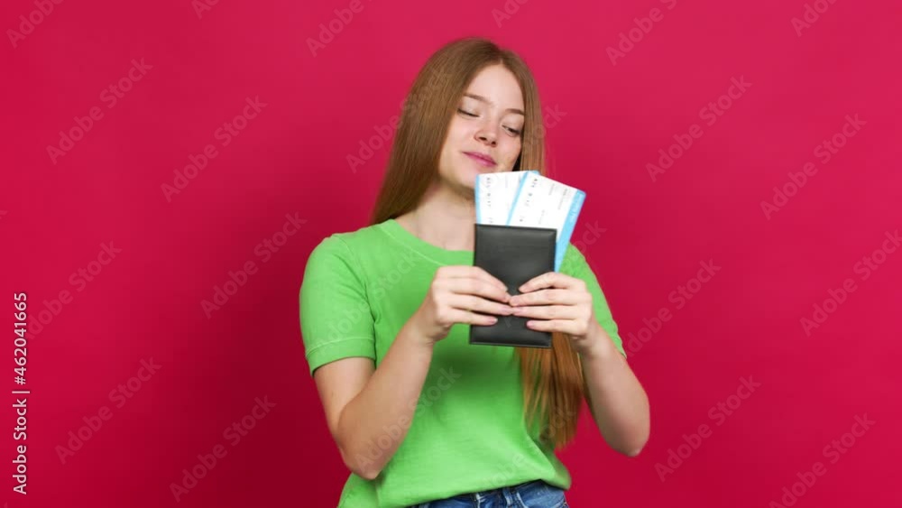 Teenager girl holding a boarding pass over isolated background Teenager girl holding a boarding pass over isolated background