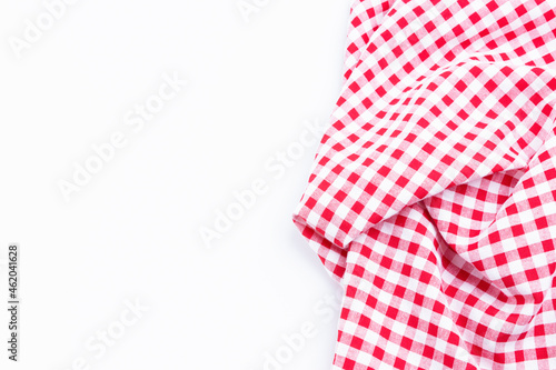 Checkers fabric crumpled top view with copy space. Red and white tablecloth texture on white background.