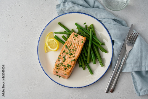 Hot salmon fillet. Fresh asparagus and lemon slices. Seasoned with parsley and olive oil. Dietary meal and good for your health. Tasty and nutritious fish with vegetables. Copy space, overhead