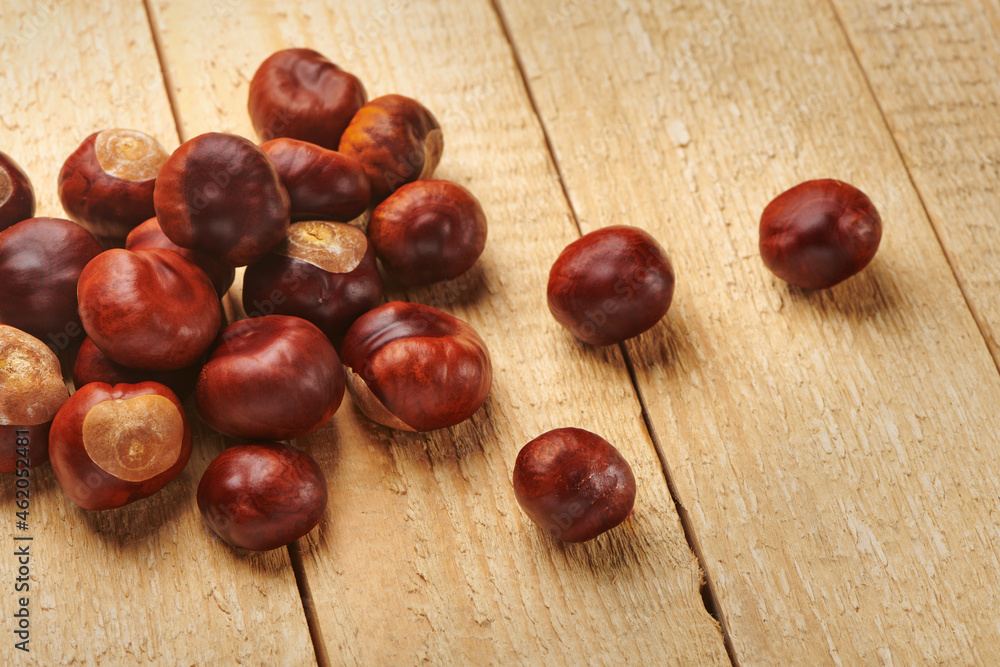 Heap of horse chestnuts on wooden table. Autumn nature harvest. Top view with copy space. Heap of horse chestnuts on wooden table. Autumn nature harvest. Top view with copy space.