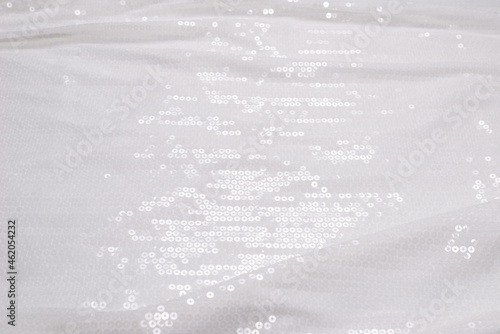 White sequin background. White shiny sequin fabric.