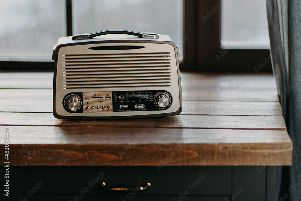 Retro vintage radio on wooden table surface near window. Back to 80s. Music  nostalgia and old technology concept. Antique recorder Stock Photo | Adobe  Stock