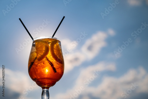 Orange drink or cocktail standing at the little table at the restaurant or cafe with sea background photo