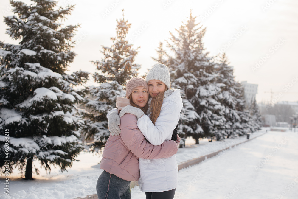 Two young athletic girls walking and playing sports on a sunny winter day. A healthy way of life. Two young athletic girls walking and playing sports on a sunny winter day. A healthy way of life.