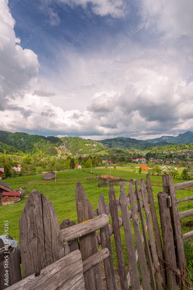 Wooden fence that serves as the border of a farm field in a valley near the Romanian Carpathians