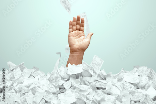 A man's hand sticks out of a mountain of checks and bills. A man is drowning in debt, credit, mortgage, loan, mortgage.