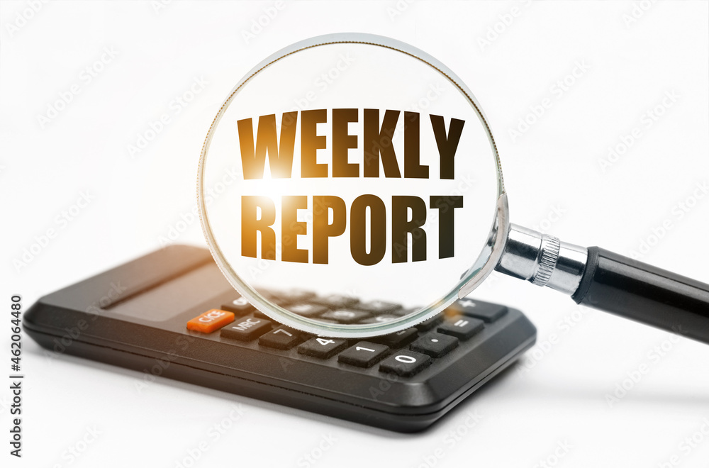 On the table is a calculator and a magnifying glass, inside which the inscription - WEEKLY REPORT On the table is a calculator and a magnifying glass, inside which the inscription - WEEKLY REPORT
