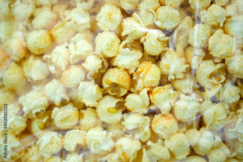 Packaging Salted popcorn with cheese flavor transparent plastic bag top view. Corn grains from Argentina that are popping open. Large grains of popcorn. Packaging Salted popcorn with cheese flavor transparent plastic bag top view. Corn grains from Argentina that are popping open. Large grains of popcorn.