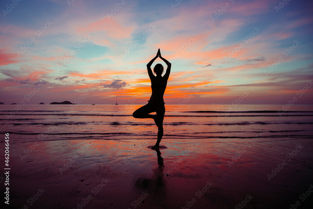Silhouette of Yoga woman meditation near the ocean beach.