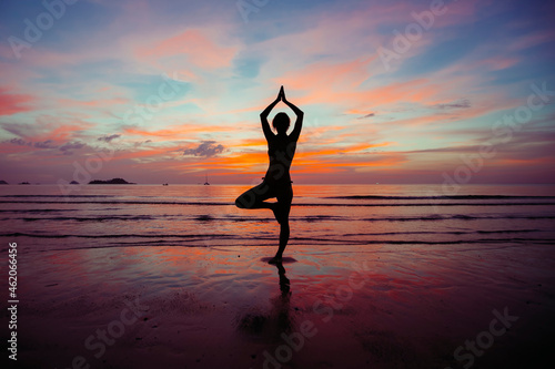 Canvas Print Silhouette of Yoga woman meditation near the ocean beach.