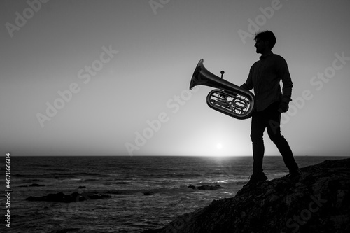 Canvas Print Silhouette of a musician man with a tuba on the sea coast