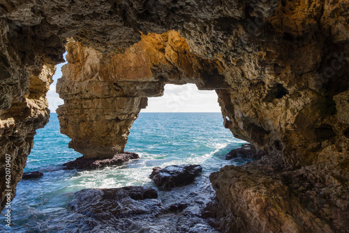 Limestone cliffs and blue water on the Mediterranean coast view of the rock cave Cova dels Arcs in Spain