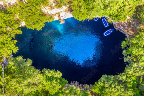 Famous tourist attraction. Aerial drone view of iconic cave with Melissani Lake near Sami village, Kefalonia island, Greece