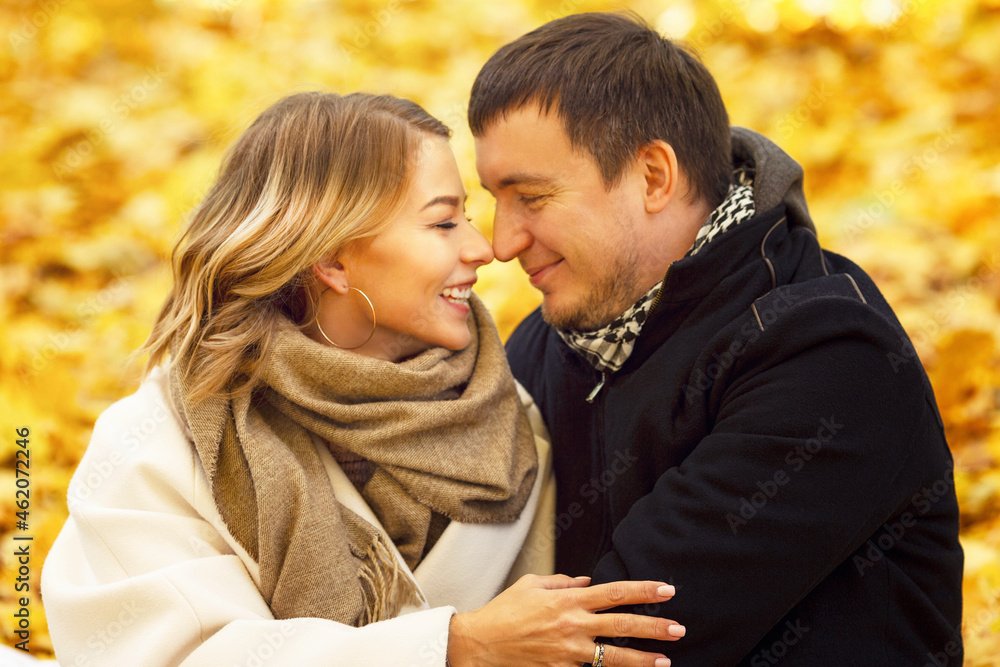 Young laughing man and woman hugging in the autumn park. Romantic couple on a date. Love and tenderness in a relationship. Close-up. Young laughing man and woman hugging in the autumn park. Romantic couple on a date. Love and tenderness in a relationship. Close-up.