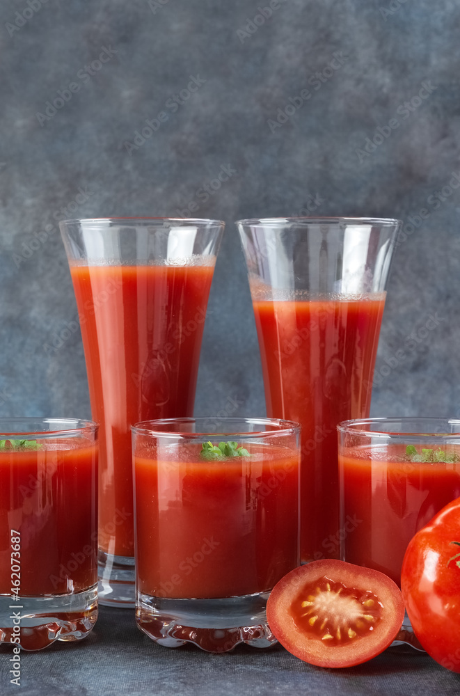 Tomato juice in a glass and fresh tomatoes on a blue vintage background. Rustic. Tomato juice in a glass and fresh tomatoes on a blue vintage background. Rustic.