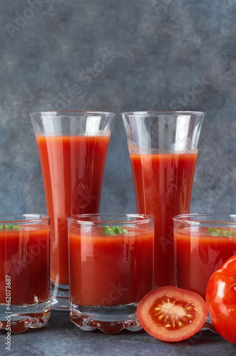 Tomato juice in a glass and fresh tomatoes on a blue vintage background. Rustic.