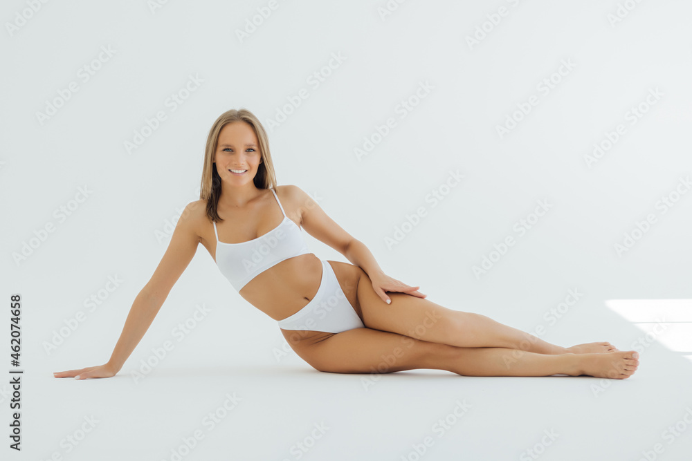 Beautiful woman with perfect body lying isolated on white background