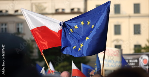 European union flag tied with flag of Poland hold by protesters during pro EU demonstration