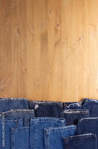 Blue jeans denim on wood table. Jeans heap at wooden background