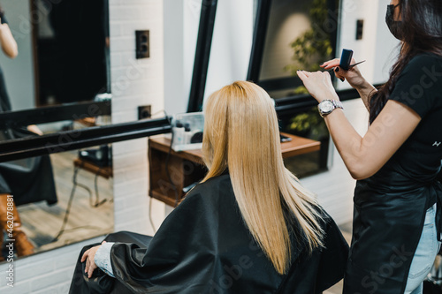 Blond middle-aged woman enjoying in modern hair salon.